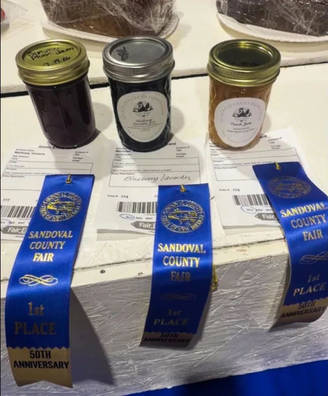Queen Cluckers jars displayed with Sandoval County Fair ribbons