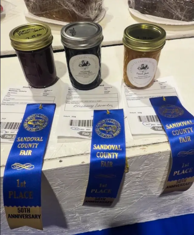 Queen Cluckers jars displayed with Sandoval County Fair ribbons