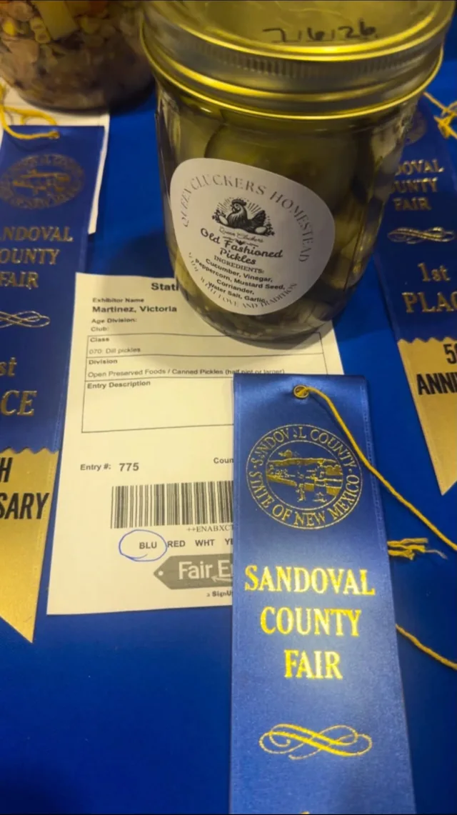 A Queen Cluckers pickle jar beside a county fair ribbon